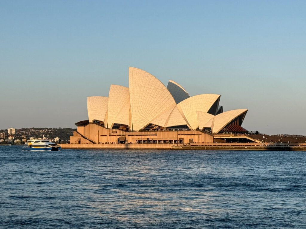 Stunning view of the Sydney Opera House during sunset with a ferry in the harbour.