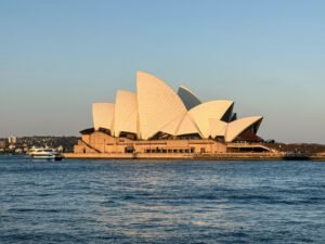 Stunning view of the Sydney Opera House during sunset with a ferry in the harbour.