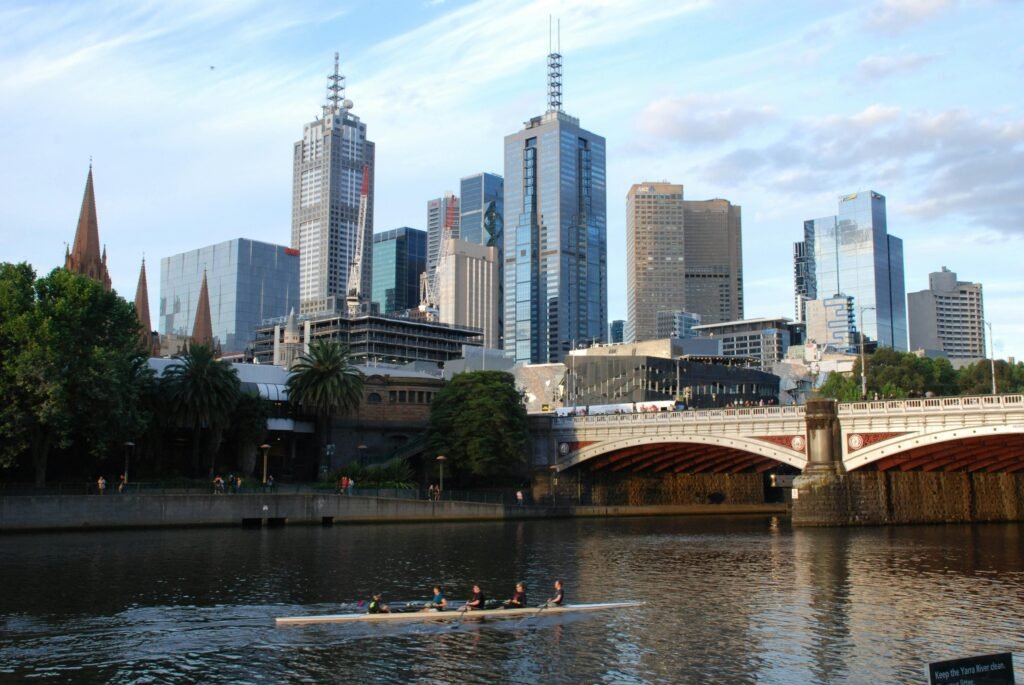 Modern skyline of Melbourne with rowers on the Yarra River, showcasing the city's blend of urban architecture and outdoor lifestyle.